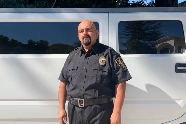 Security Guard John of OPSINC providing unarmed protection at an event while posing in front of a party bus